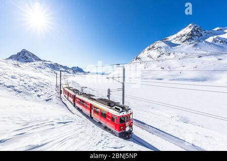 Bernina Express transit along Lago Bianco in winter, Bernina Pass, Engadine, Canton of Graubunden, Switzerland, Europe