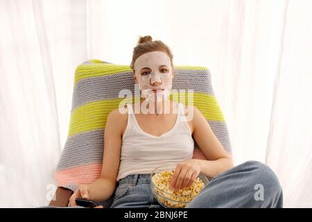 Woman with a remote and popcorn Stock Photo