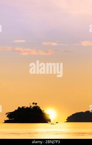 The sun setting behind islets in the Banda archipelago, Banda, Maluku, Spice Islands, Indonesia, Southeast Asia, Asia Stock Photo