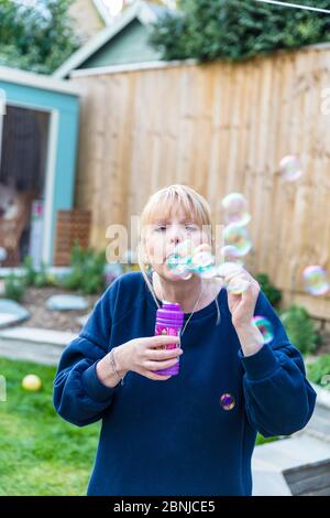 woman blowing bubbles, blowing bubbles, bubble wand, adult blowing bubbles, bubble, bubbles, blowing, soap bubbles, fun, playing with bubbles, Stock Photo