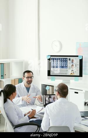 Group of doctors working in team during meeting at office they sitting at the table and discussing x-ray images Stock Photo