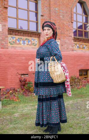 Woman with a basket in retro clothes of the 19th century. Antique clothing of the late 19th century. Beautiful dress and skirt on a woman. Beads and Stock Photo