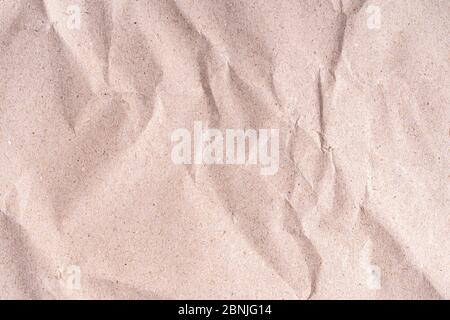 Old wrinkled brown craft paper poster texture. Blank creased crumpled grainy beige kraft paper textured surface. Smudged grungy cardboard with fibers. Stock Photo