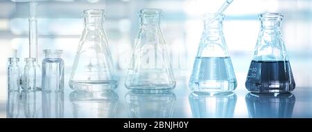 glass flask and vial experimental set medical health research science blue laboratory equipment and water solution web banner design background Stock Photo