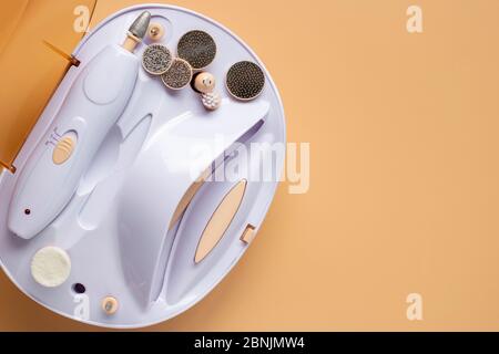 Set for home manicure with various nozzles on a beige background. Stock Photo