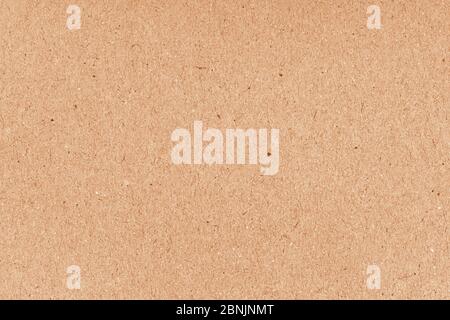 Brown grainy corrugated cardboard surface. Beige carton plain surface. Grain paper texture. Paper box for packing. Cardboard grunge recycled craft pap Stock Photo