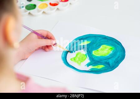 Child draws planet for earth day. Protection of environment. Earth Day celebration. Save world and unity concept. Stock Photo