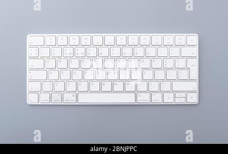 Close-up white keyboard on gray desk, top view of modern computer keyboard isolated on gray background Stock Photo