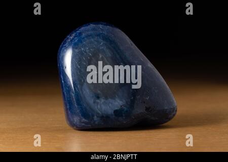 Polished blue agate gemstone from Brazil over a wooden table Stock Photo