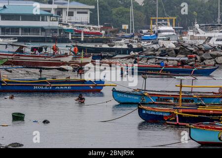 Manila. 15th May, 2020. Fishermen swim to catch crabs under the downpour brought by typhoon Vongfong in Manila Bay, the Philippines on May 15, 2020. Typhoon Vongfong tore off roofs and shook trees as it made landfall in central Philippines' Eastern Samar province at 12:15 p.m. local time on Thursday, authorities said. Vongfong is the first typhoon to batter the Philippines this year as the country grapples with the fallout of COVID-19 pandemic. Credit: Rouelle Umali/Xinhua/Alamy Live News Stock Photo