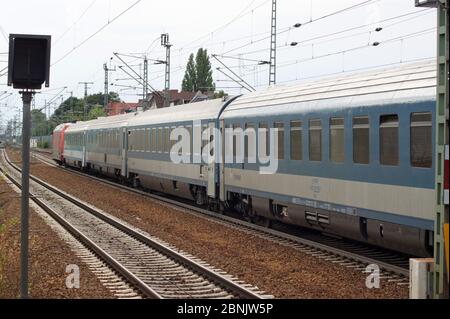 Zug mit Wagen der Ungarischen Staatsbahn bei der Ausfahrt aus dem Bahnhof Berlin-Spandau in Richtung Hamburg Stock Photo