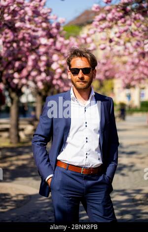 Business man with sunglasses in front of cherry trees Stock Photo