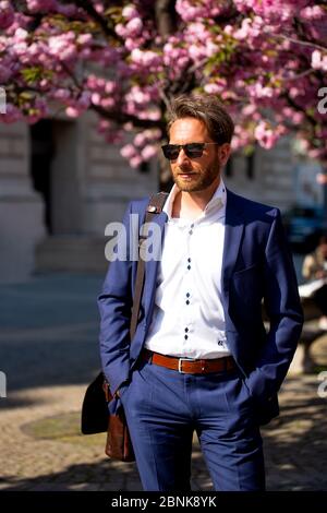 Business man with sunglasses in front of cherry trees Stock Photo