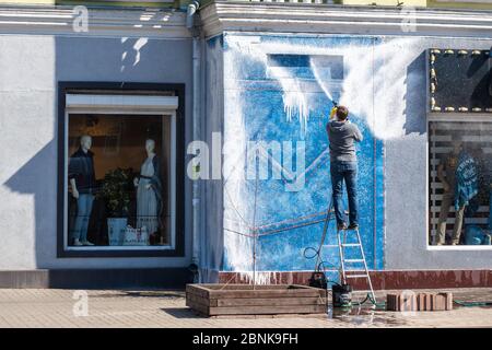 A man washes the facade and shop windows. Modern equipment and cleaning products for washing and cleaning. Preparing the store for opening. Stock Photo