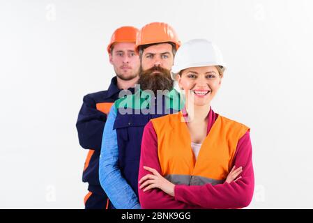 Cheerful team of three constructor workers in hard hats standing with arms folded isolated on white background, copy space Stock Photo