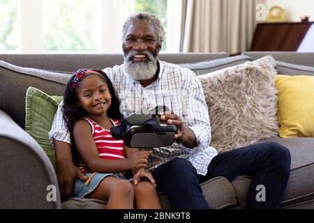 Senior African American man and his granddaughter using vr headset Stock Photo
