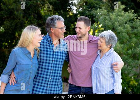 Senior Caucasian couple and their adult son and daughter spending time together in the garden Stock Photo