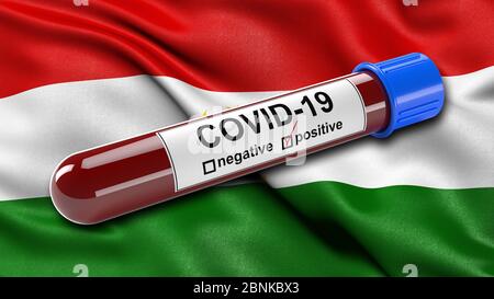 Flag of Tajikistan waving in the wind with a positive Covid-19 blood test tube. Stock Photo