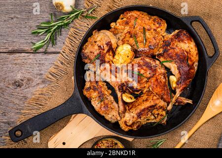 Braised Fried Rabbit with Rosemary, Garlic and Olive Oil on Wooden Background. Stock Photo
