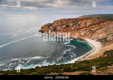 Lagosteiros beach, seen from Nossa Senhora do Cabo sanctuary, clear blue water, cliffs lining up in the in the middle and Sintra in background Stock Photo