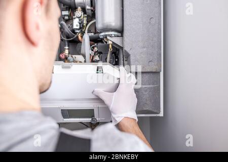 Close Up Of Caucasian Service Worker Fixing Central Heating Furnace System. Stock Photo