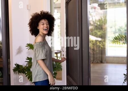 Mixed race woman holding a door handle Stock Photo