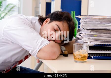 Young businessman employee drinking in office Stock Photo