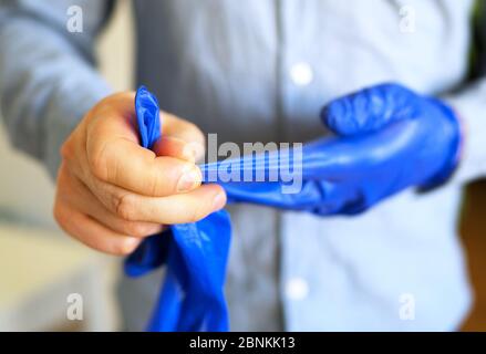 Man takes off his medical gloves. Covid-19 prevention. Stock Photo