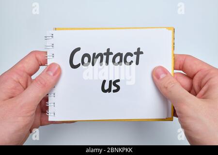 Lettering on paper contact us as a feedback concept. Close up. Stock Photo