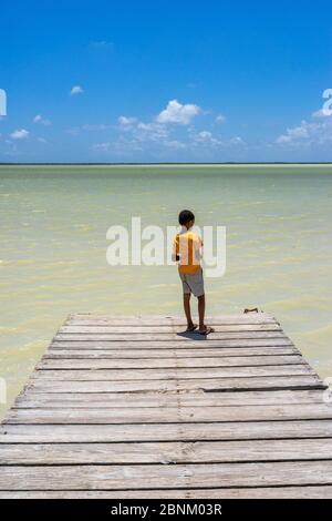 America, Caribbean, Greater Antilles, Dominican Republic, Oviedo, Laguna de Oviedo, boy stands on the jetty at the Laguna de Oviedo salt water lake Stock Photo