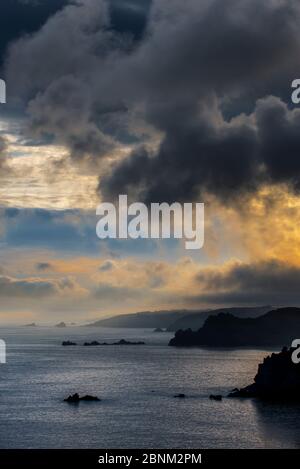 Sea cliffs at the Pointe de Penharn at sunrise with storm clouds, Cleden-Cap-Sizun, Finistere, Brittany, France, September Stock Photo