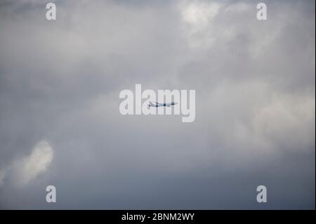 passenger plane flying in the stormy dramatic sky. the sun shines from behind the clouds. the plane flies Stock Photo