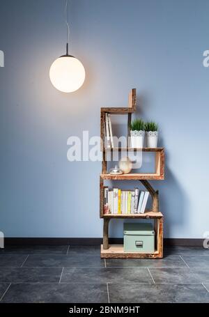 Construction of a wooden shelf, do-it-yourself production, final photo 02 in front of a light blue wall Stock Photo