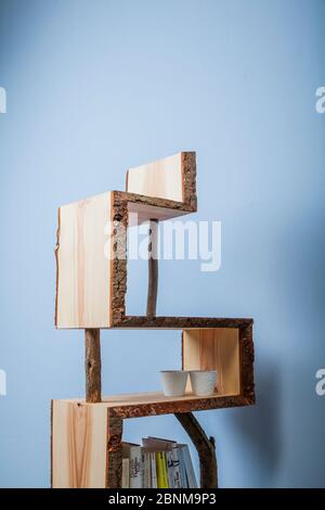 Construction of a wooden shelf, do-it-yourself production, final photo 04 against a light blue wall Stock Photo