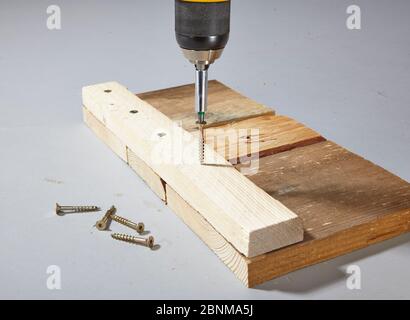 Construction of a shelf made of wood, Euro pallet, solid wood, MDF board; Do-it-yourself production, step-by-step, step 4 Connect the individual boards with wooden strips and screws Stock Photo