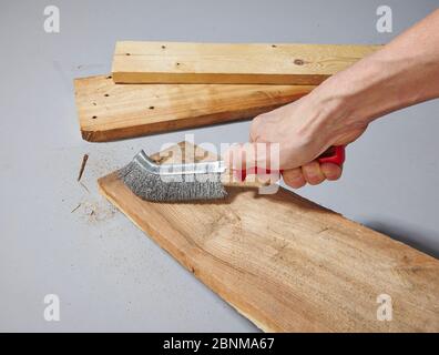 Construction of a shelf made of wood, Euro pallet, solid wood, MDF board; Do-it-yourself production, step-by-step, step 2 Remove coarse dirt and wood chips with a wire brush Stock Photo