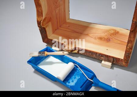 Building a wooden shelf, do-it-yourself production, step-by-step, step 17c painting the finished glued furniture with water-soluble acrylic paint, first painting the corners with a brush, then painting the surfaces with a foam roller Stock Photo