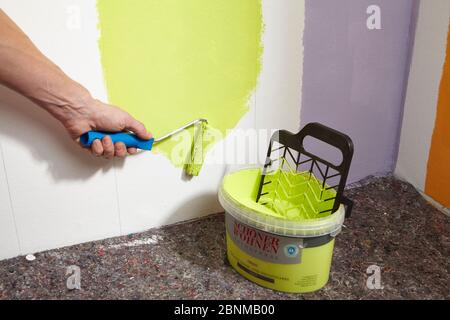 DIY wall design 01, step-by-step do-it-yourself production, vertical colored stripes in the lower wall area, step 03 coloring every second stripe with colored wall paint over the pencil lines Stock Photo
