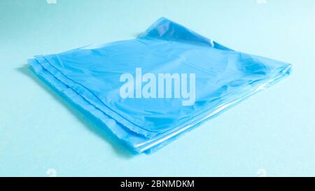 One torn plastic garbage bag in blue on a blue background. A bag that is designed to accommodate garbage in it and is used at home and placed in vario Stock Photo