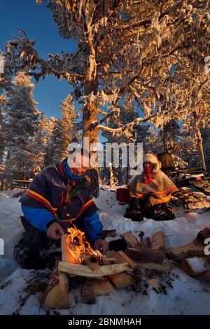 Nils-Torbjorn Nutti, owner and operator at Nutti Sami Siida, and Klara Enbom-Burreau on snowmobile trip into the wilderness, Jukkasjarvi, Lapland, Lap Stock Photo