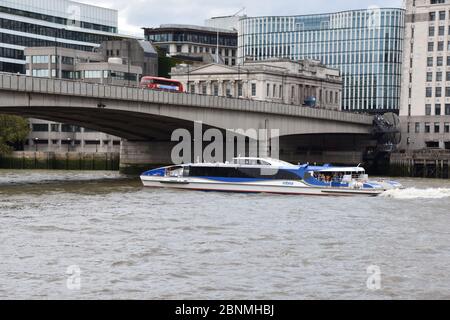 A cruise boat in The River Thames, London, England, UK just about to go underneath London Bridge Stock Photo