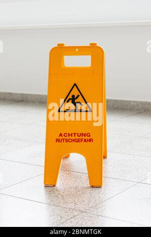 Safety sign warns about wet floor near entrance area Stock Photo - Alamy
