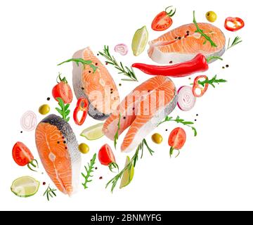 Raw steaks of salmon fish flying with spices and herbs isolated on white background. Stock Photo