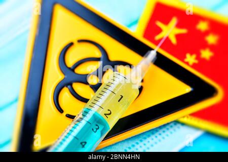 Syringe, biohazard sign and flag of China on a face mask, symbol photo Corona virus Stock Photo