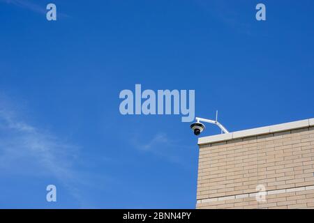 A security camera on a building overlooking a sidewalk with copy space. Stock Photo