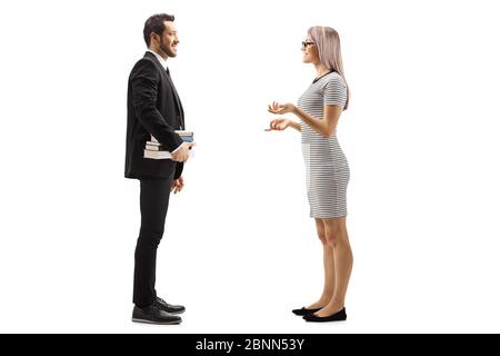 Full length profile shot of a man in a black suit holding books and talking with a blond young woman isolated on white background Stock Photo
