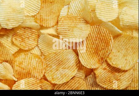 Slices Golden chips with stripes lying slides background texture. View from above. Stock Photo