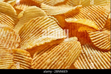 Slices Golden chips with stripes lying slides background texture. Side view. Stock Photo