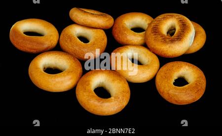 Bagels of golden color isolated on black background Stock Photo