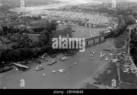 AJAXNETPHOTO. 1979. BURSLEDON, ENGLAND. - YACHTING MECCA - AERIAL VIEW OF THE FAMOUS HAMBLE RIVER WINDING SOUTH WEST TOWARD SOUTHAMPTON WATER AND THE SOLENT. FOREGROUND IS RIVERSIDE BOATYARD, THE BURSLEDON RAILWAY HAMBLE RIVER CROSSING VIADUCT WITH A27 ROAD BRIDGE CENTRE RIGHT, POOL OF BURSLEDON AND MOODY'S MARINA TOP.PHOTO:JONATHAN EASTLAND/AJAX REF:1979 3054 Stock Photo